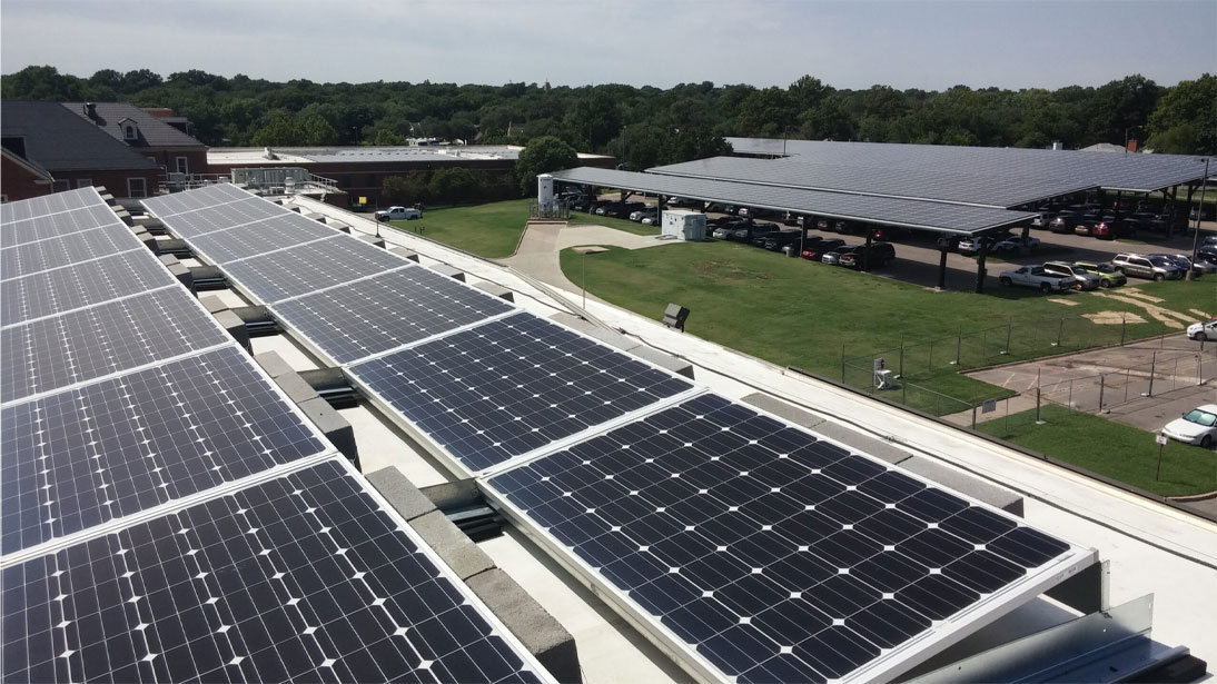 An aerial shot of a building with solar panels on its roof, harnessing the power of the sun.